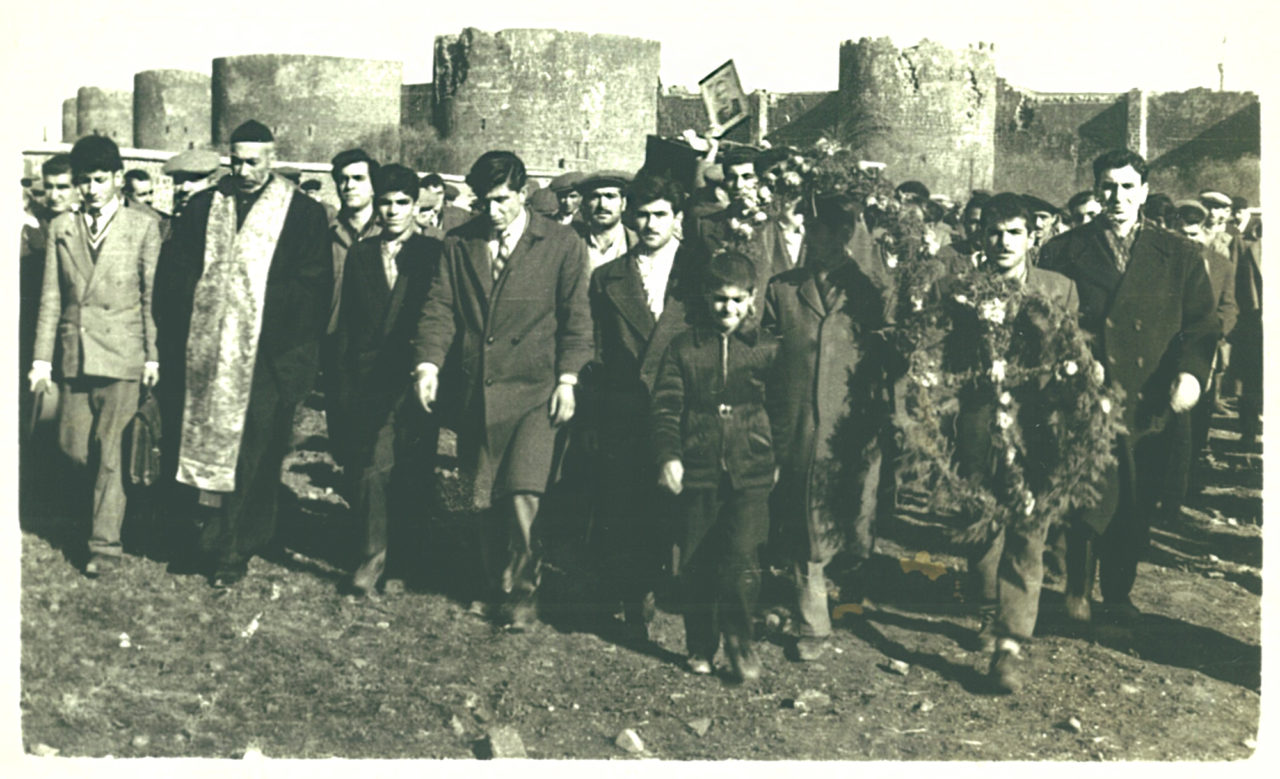Assyrians believe that with death, earthly suffering ends and eternal life begins. As the coffin is brought out of the church, the traditional ululation (tilili) is performed, and a single ring of the church bell is heard. Then, the clergyman leads the procession to the cemetery. The photograph shows a funeral procession heading to the Assyrian Cemetery immediately outside Urfakapı. (Photograph: The Can Şakarer archive)